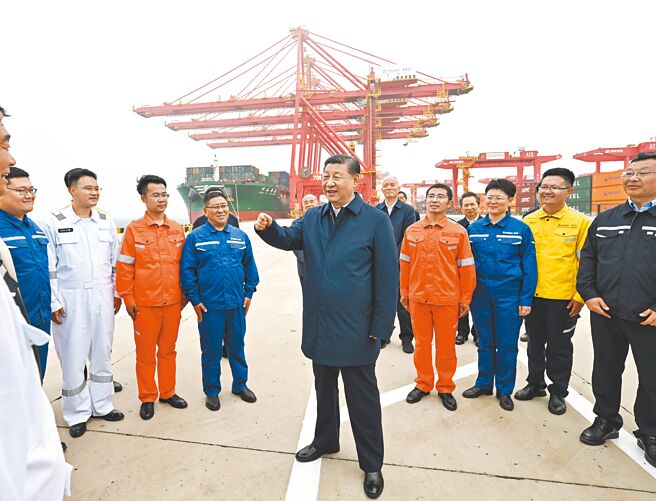 中共中央總書記、國家主席習近平（中）22日在山東省日照市考察調研。圖為習近平在日照港了解港口智慧化及綠色化建設、擴大對外開放等情況。（新華社）