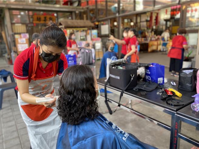 彰化县和美无极龙华慈惠堂等民间慈善团体与善心人士25日举办寒士庆端阳活动，发放端午肉粽、超商礼券200元及生活物资给110名寒士外，还邀请彰化县美容美髮职技研训协会杨老师团队8名设计师提供义剪服务。（孙英哲摄）