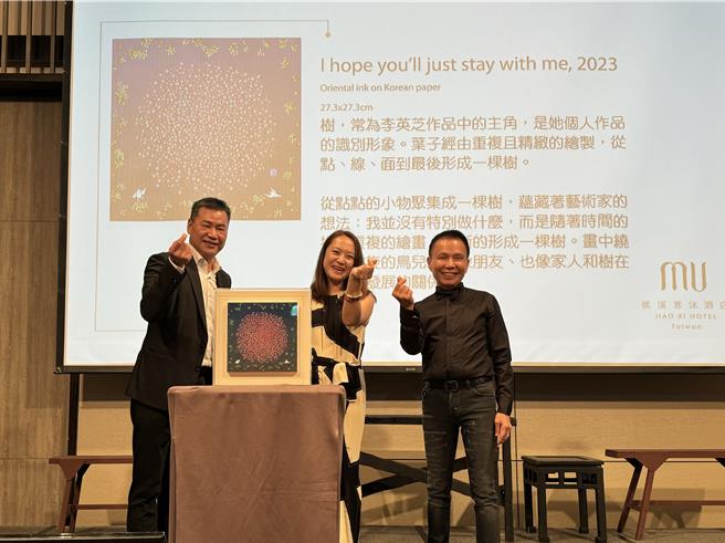 畫作從6萬元起賣，經數次喊價後由藍正雄先生（右）以20萬元買下。（吳佩蓉攝）