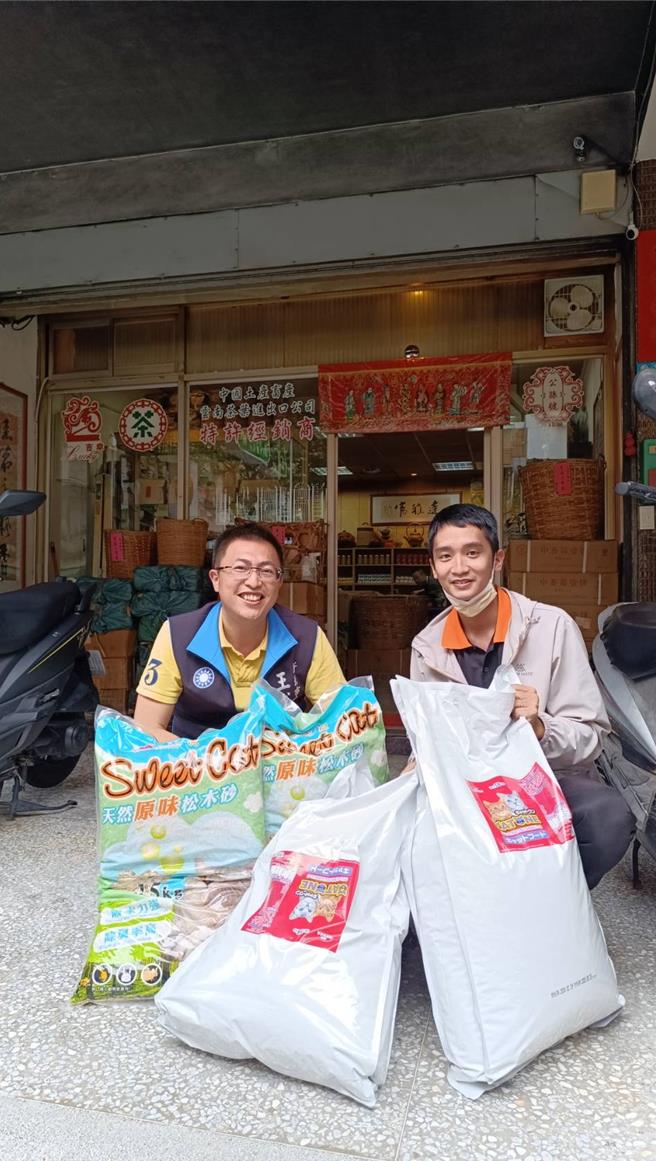 议员王威元（左）与陈姓房仲（右）一同搬运猫砂跟饲料。（新北市议员王威元提供／张铠乙新北传真）