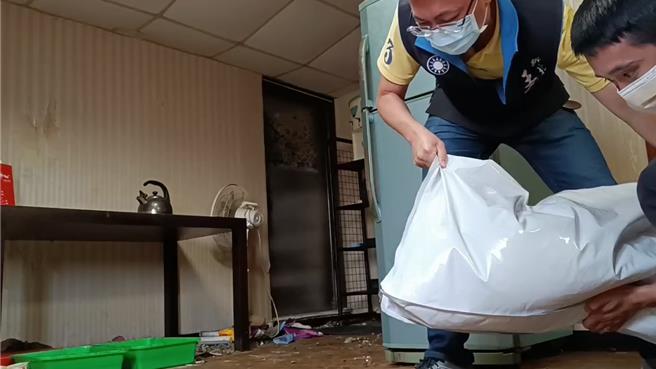 议员王威元（左）与陈姓房仲（右）一同搬运猫砂跟饲料到顶楼租屋处。（新北市议员王威元提供／张铠乙新北传真）