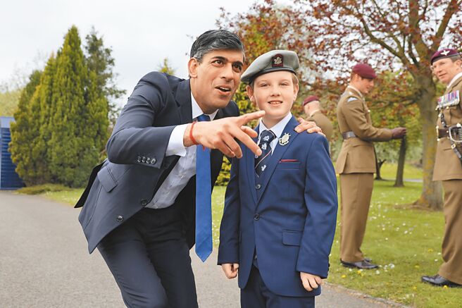 英相苏纳克宣布，若保守党大选后继续执政，将重启义务役。图为苏纳克（左）于5月3日在卡特里克检阅驻军部队，其间与军人家属亲切互动。（摘自英国首相官邸官网）