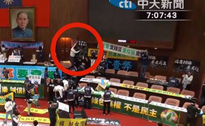 國民黨立委謝龍介（白衣者）協助民進黨立委吳沛憶張貼海報。（圖 / 擷取自中天新聞YouTube）