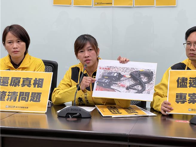 市議員蔡惠婷拿出現場新聞照片指出，現場消防人員使用的無線電，疑似有電線外露，用膠帶纏繞後繼續使用。（王惠慧攝）