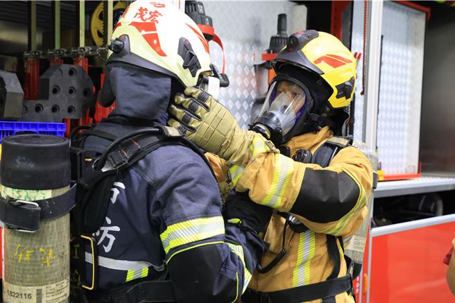 消防隊員展示了從頭盔、消防衣帽鞋到空氣呼吸器的全套裝備。（翻攝照片／洪靖宜高雄傳真）
