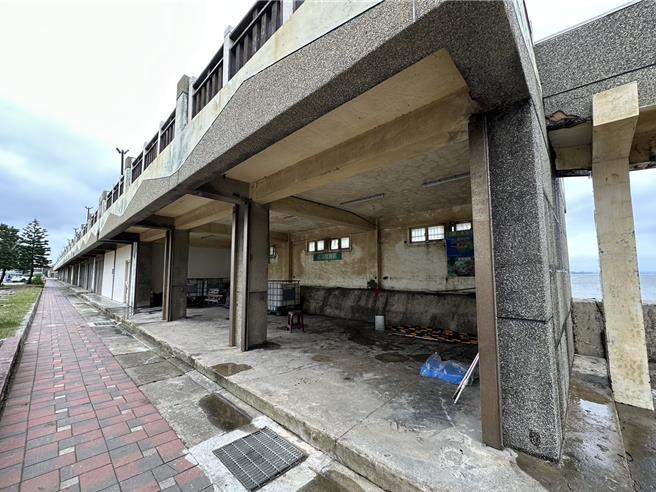 桃园市永安渔港停车场旁仓库閒置多年遭批评像废墟，市府农业局说，该处作为渔港管理物资仓库使用，因强风容易导致铁卷门损坏使用上受限，后续活化将朝整体设施改善及景观再造方向进行。（吕筱蝉摄）