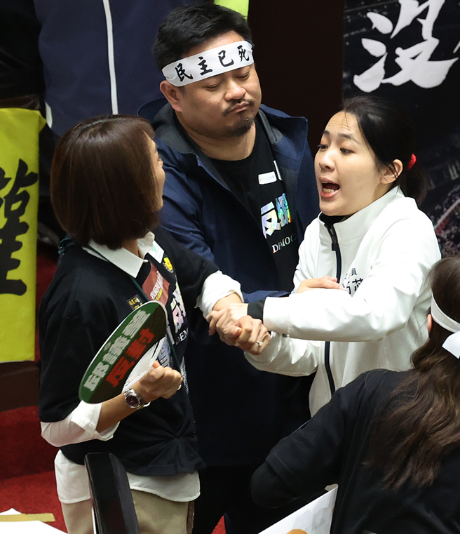 立法院院會28日續審國會改革相關法案，在接近二讀完成前，藍綠衝突卻突然升溫，民進黨立委邱議瑩（左）衝上前打了國民黨立委羅智強，並欲揮掉羅的直播手機，國民黨立委徐巧芯（右）見狀也衝上前聲援，並與邱議瑩發生拉扯。（劉宗龍攝）