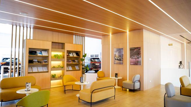 遵循「Kia Store」的空間概念，客戶區利用井字型燈光設計，搭配大量木質建材交錯，打造貼近自然、無壓力感受。（台灣森那美起亞提供）