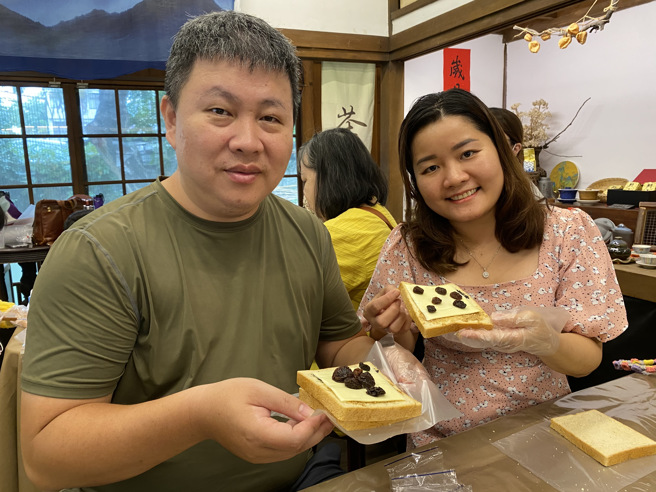 越南新住民紅青(右)和丈夫開心地展示手作健康三明治。(移民署嘉義市服務站提供)