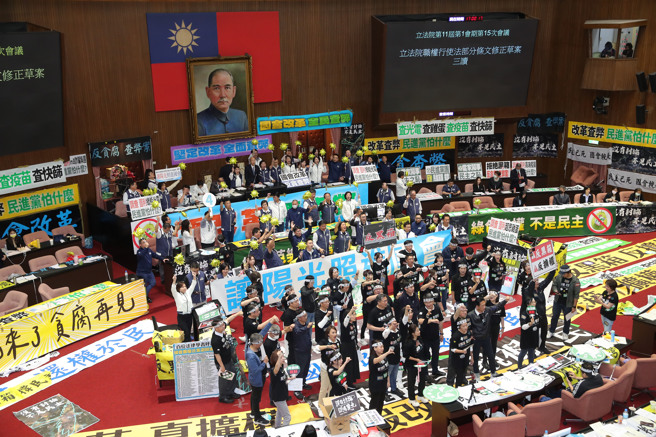 立法院院会28日续审国会改革相关法案，傍晚时全案三读包裹表决，国民党、民眾党以人数优势完成三读程序，立法院长韩国瑜在三读通过后敲槌，国民党立委手持太阳造型气球高喊支持，民进党立委们则在台下比倒讚抗议。（黄世麒摄）