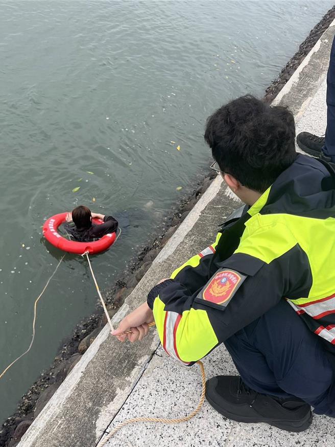 員警獲報到場，第一時間將岸邊救生圈丟給女子。（淡水警分局提供）