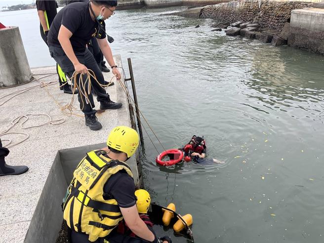 消防局滬尾分隊隊員呂易陞下水游至莊女身旁，將她拉回岸邊。（新北市消防局提供）