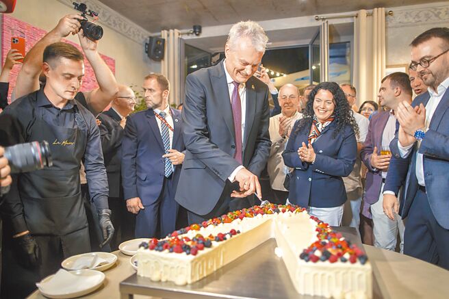 立陶宛26日進行總統大選第2輪投票，現任總統瑙塞達確定將勝選連任。圖為瑙塞達（中）與競選團隊成員切蛋糕慶祝勝選。（美聯社）