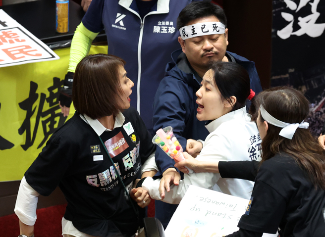 民進黨立委邱議瑩（左）衝上前打了國民黨立委羅智強，並欲揮掉羅的直播手機，國民黨立委徐巧芯（右）見狀也衝上前聲援，並與邱發生拉扯。（中時資料照，劉宗龍攝）
