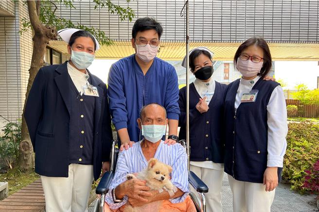 花蓮1名67歲獨居陳姓男子（前中）罹患肺腺癌第4期，擔心愛犬「阿吉」無人照養拒絕治療，經醫療團隊接力照顧犬隻，成為牠的「中途之家」，便打開心房接受療程，日前在病況穩定時與阿吉相聚，見其可愛笑容彷彿獲得勇氣，允諾會繼續與病魔對抗，早日一家團圓。（花蓮慈濟醫院提供／羅亦晽花蓮傳真）