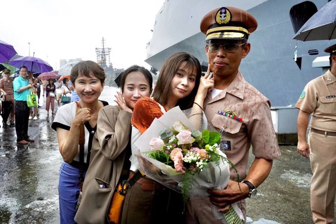 支队长王田少将家人献花拥抱。( 国防部提供 )