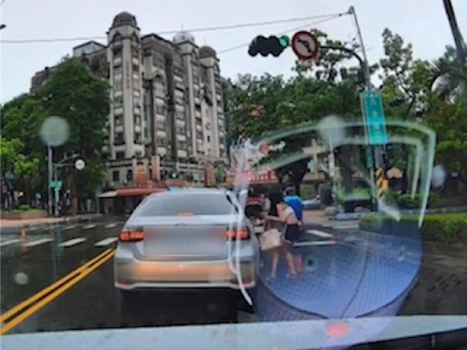 該名女子從候車廂爬出後，跑到副駕座位開門入座，讓後車駕駛看傻。（翻攝自WoWtchout - 地圖型行車影像分享平台／任義宇高雄傳真）