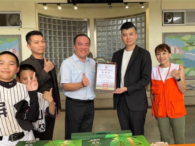郡都集团董事长唐承（右二）29日代表郡都集团，捐赠善款10万元，由屏山国小校长沈佑霖（左二）代表接受。图／郡都集团提供