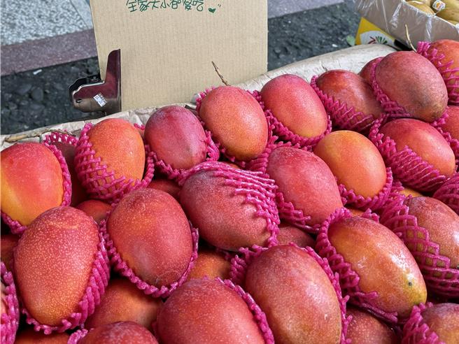 水果行簡老闆表示，消費者若選購芒果時可注意表皮是否變紅，尾巴不要綠色的，較會酸。（吳佩蓉攝）