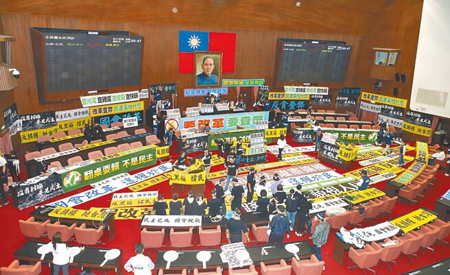 立法院国会改革相关法案28日院会三读，一早议场开门后，国民党及民进党立委用布条标语布置场内，展现各自诉求。（刘宗龙摄）
