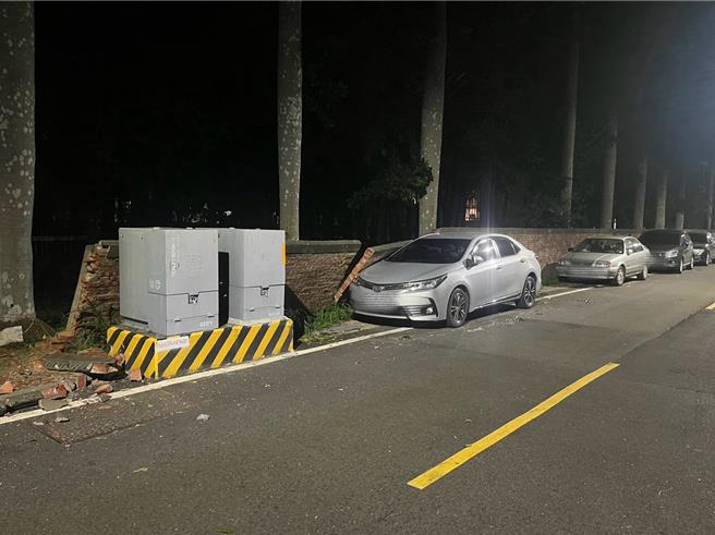 一辆银色轿车被围墙压到，警方到场立即联繫其他停在围墙旁的车主移车。（读者提供／张毓翎台南传真）