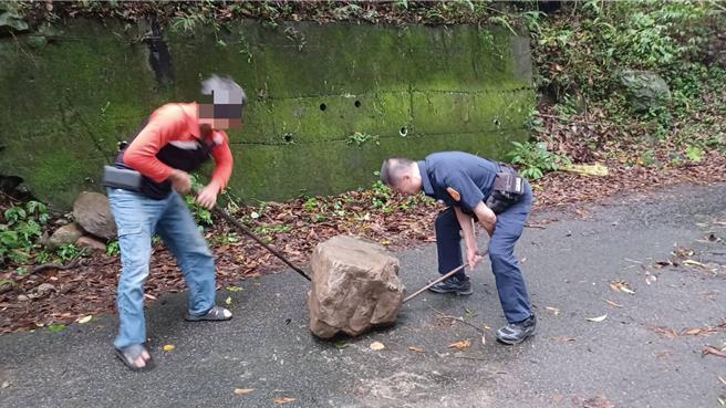 和平地区连日豪雨，在中专一线育才巷横硫溪旁道路巡逻时，有1颗巨石挡在路中央，警方合力将大石头搬开。（照片由警方提供）
