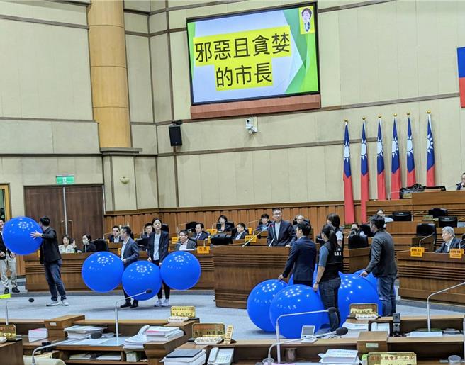 基市議會民進黨團進行總質詢，痛批基隆市長謝國樑的施政有諸多問題，說他「邪惡又貪婪」，帶了大氣球進議場要戳破真相。（張志康攝）