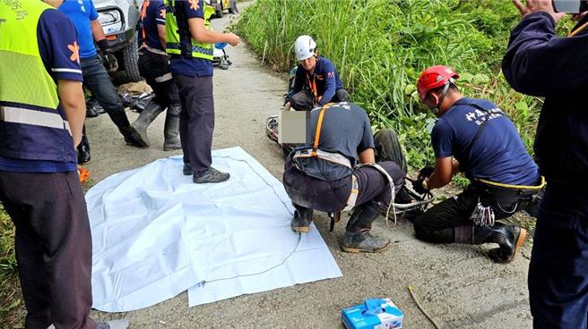 搜救人员徒手搬运压埋在驾驶身上的大型石块及H型钢，驾驶救出时明显死亡。（南投县消防局提供／杨静茹南投传真）