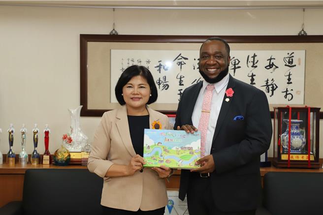 雲林縣長張麗善（左）贈送《戀戀雲林溪川越斗六門畫畫雲林溪》給聖克里斯多福及尼維斯的大使范東亞。（雲林縣府提供）