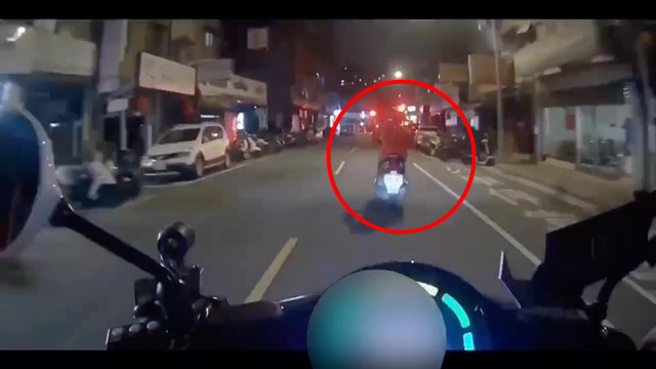 一名機車騎士未開車燈，員警上前提醒時，未料該騎士突然加速駛離。（翻攝畫面）