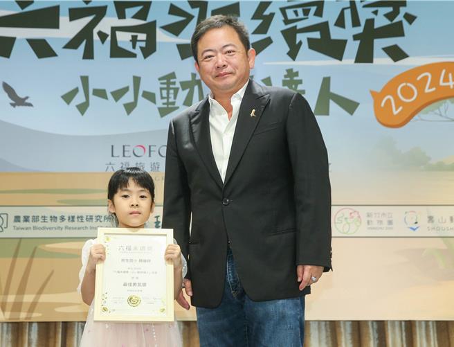 庄福文教基金会董事长赖振融（右）颁发勇气奖给民生国小的顏睿妤同学，表扬她不畏身体限制勇于表现。（粘耿豪摄）