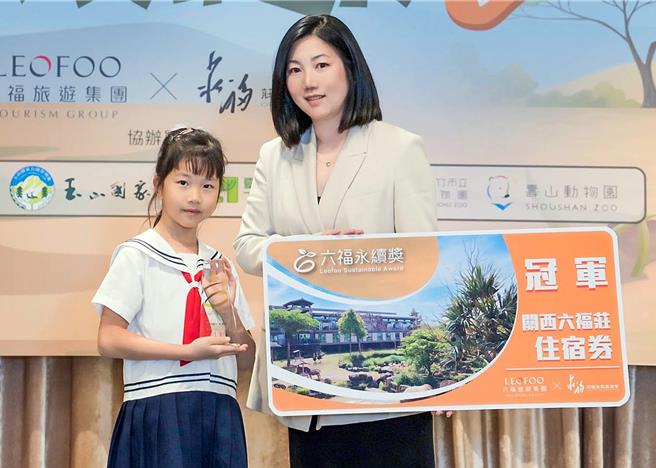 六福旅游集团董事长庄丰如（右）表示六福旅游集团将持续朝环境永续方向努力，图为她颁发英文组国小中年级冠军奖予敦化国小林昱晴同学（六福万怡提供／粘耿豪台北传真）