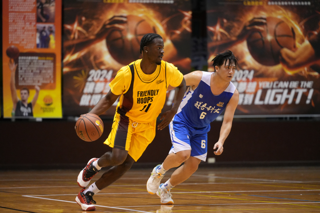 NCAA球員Solomon(左)發動快攻，醒吾科大籃球隊員黃濬彥加速趨前防守。(醒吾科大提供)