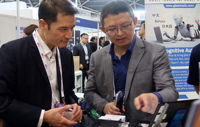 集思智能执行长姜昱有向驻新加坡台北代表处参事兼经济组组长吴文忠(左一)介绍公司产品。(图/新北市政府青年局提供)