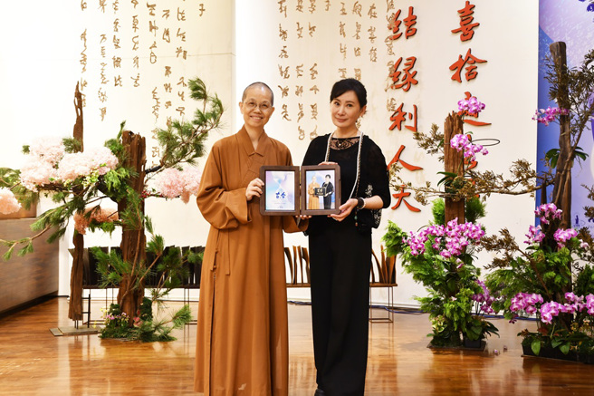 觉居法师(左)致赠讲座纪念照片给主讲人陈亚兰(右)。(图/佛光山惠中寺提供)