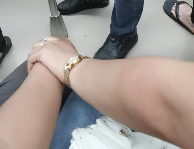 男子搭車時遇到情侶，不料，對方竟坐在他的兩旁，並且越過他的腿「懸空拉拉手」，讓他超級傻眼。（圖／翻攝自微博）