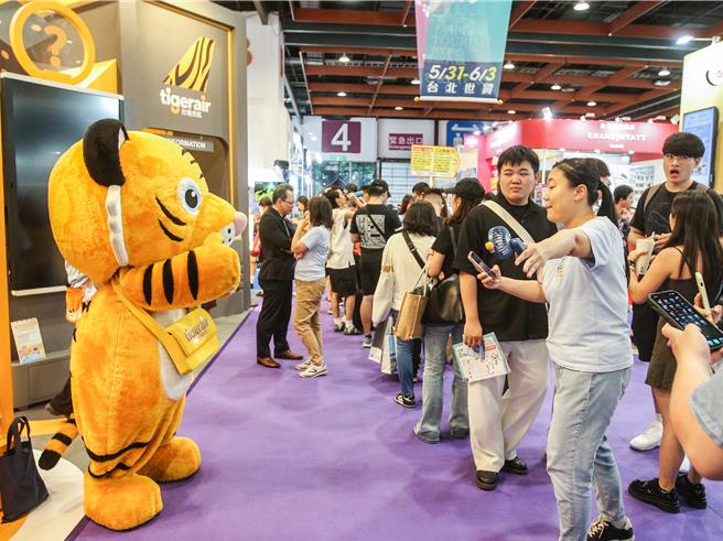 台湾虎航展场安排老虎人偶促销机票，受到民眾欢迎。（粘耿豪摄）