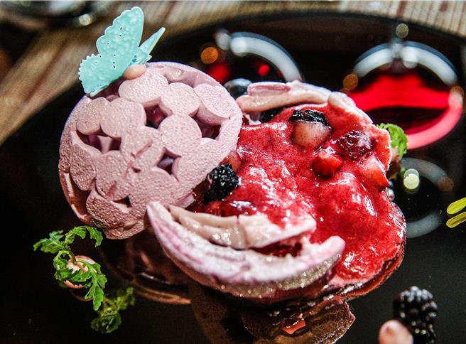 巴赛丽厅的覆盆子瓦戌航冰淇淋蛋糕，是将蛋白霜做成篓空的球体，包覆覆盆子雪酪，不仅视觉感十足，外硬内软的口感更具衝击。（粘耿豪摄）