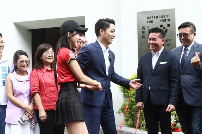台北市長蔣萬安（右三）在青年局揭牌儀式合照時，特別牽起味全龍啦啦隊「小龍女」李多慧（右四）的手，將其引導到「C位」一同合照留念。（丁上程攝）