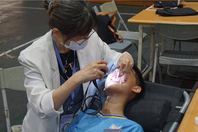 牙医师检测学生牙菌斑指数。（罗琦文摄）