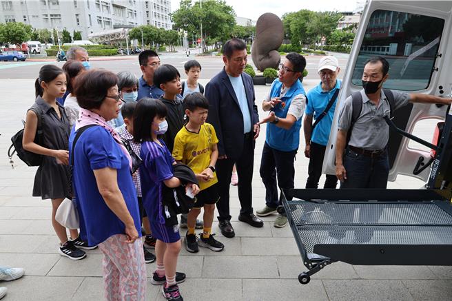 新北市魏氏家族22人，齊聚苗栗縣政府以父母親名義捐贈1部復康巴士給苗栗縣政府，苗栗縣長鍾東錦陪同家屬查看巴士起降設備操作。（謝明俊攝）