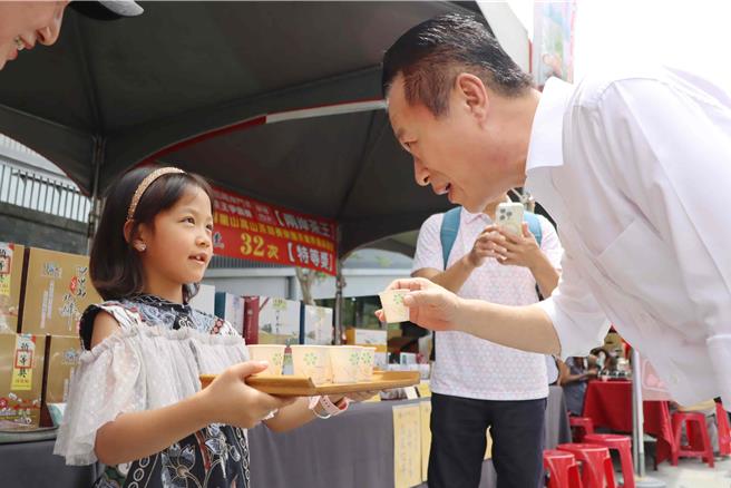 阿里山農會選在阿里山國家風景區管理處前廣場辦頒獎和展售會，小二女童熱情招呼大家品茶，嘉義縣長翁章梁特別上前捧場。（呂妍庭攝）
