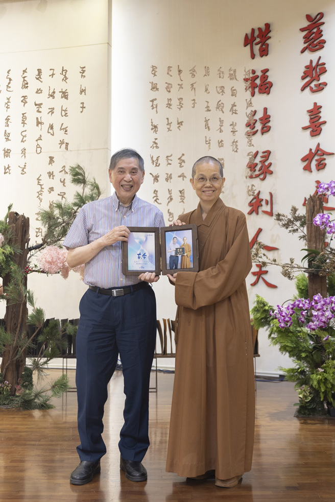 覺居法師 (右) 致贈講座紀念照片給主講人白先勇(左)。(圖/佛光山惠中寺提供)