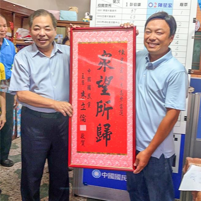 新竹县芎林乡县议员补选1日顺利投开票，国民党新竹县党部主委陈见贤（左）致赠「眾望所归」匾额，祝贺陈星宏（右）当选县议员。（罗浚滨摄）