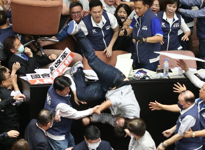 民进党立委沈伯洋，517试图从主席台后门爬到蓝绿立委头上衝进议场，但随后从主席台上跌落。（中时资料照／赵双杰摄）