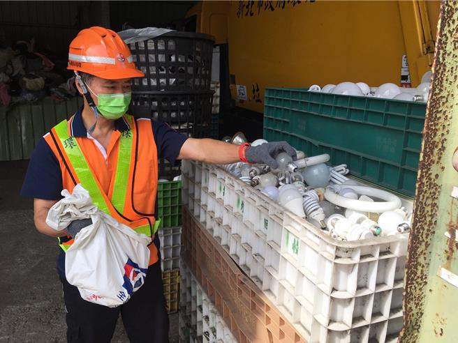 万里区清洁队高员某日处理资源回收物时，发现一袋回收灯泡里面遗留了现金20万元，立即通报区队干部并至警局报案。（新北市环保局提供）