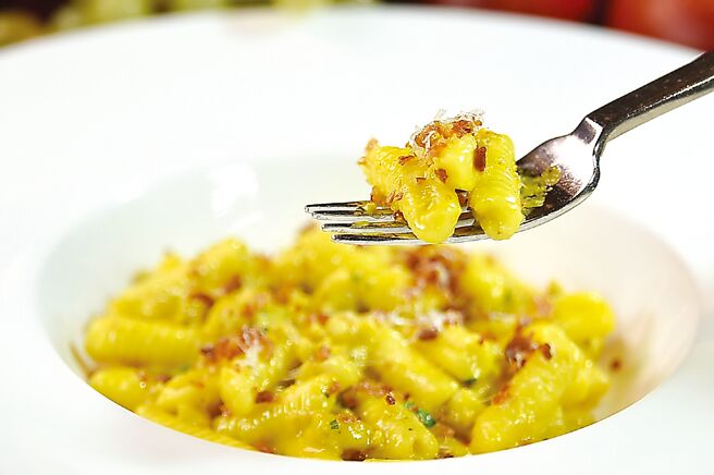 〈手工扭指麵佐番红花奶油衬义大利香肠〉用番红花奶油酱汁炒麵，并加煎炙的义大利香肠丁与现刨佩寇里诺羊奶乾酪提味增鲜。图／姚舜