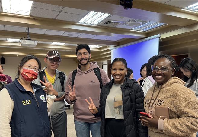 移民官高琳乔（左一）和与会应届毕业生合影（中为宏都拉斯籍Miguel、右二为海地籍Christinne）。（移民署提供）