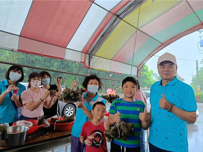 薛小弟一家參加埔心社區親子包肉粽活動，由阿嬤領軍，帶著媳婦及2位女兒，還有4位孫子一起來包肉粽，阿嬤說，希望將端午節包肉粽的傳統能傳承下去，埔心村社區發展協會理事長許增鏞（右）歡迎大家一起來參與。（葉靜美攝）