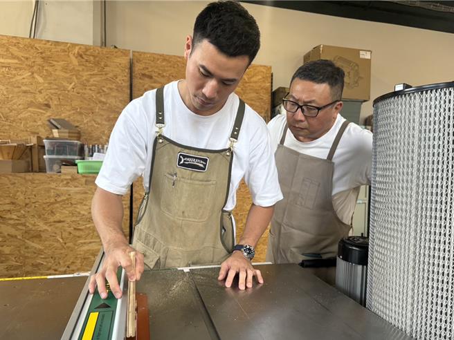 卢秀雄（后）、卢柏宇（前）在工作室相互激盪发想，也常拌嘴，但磨合过后，寄木工艺更加完美。（高雄市政府青年局提供）